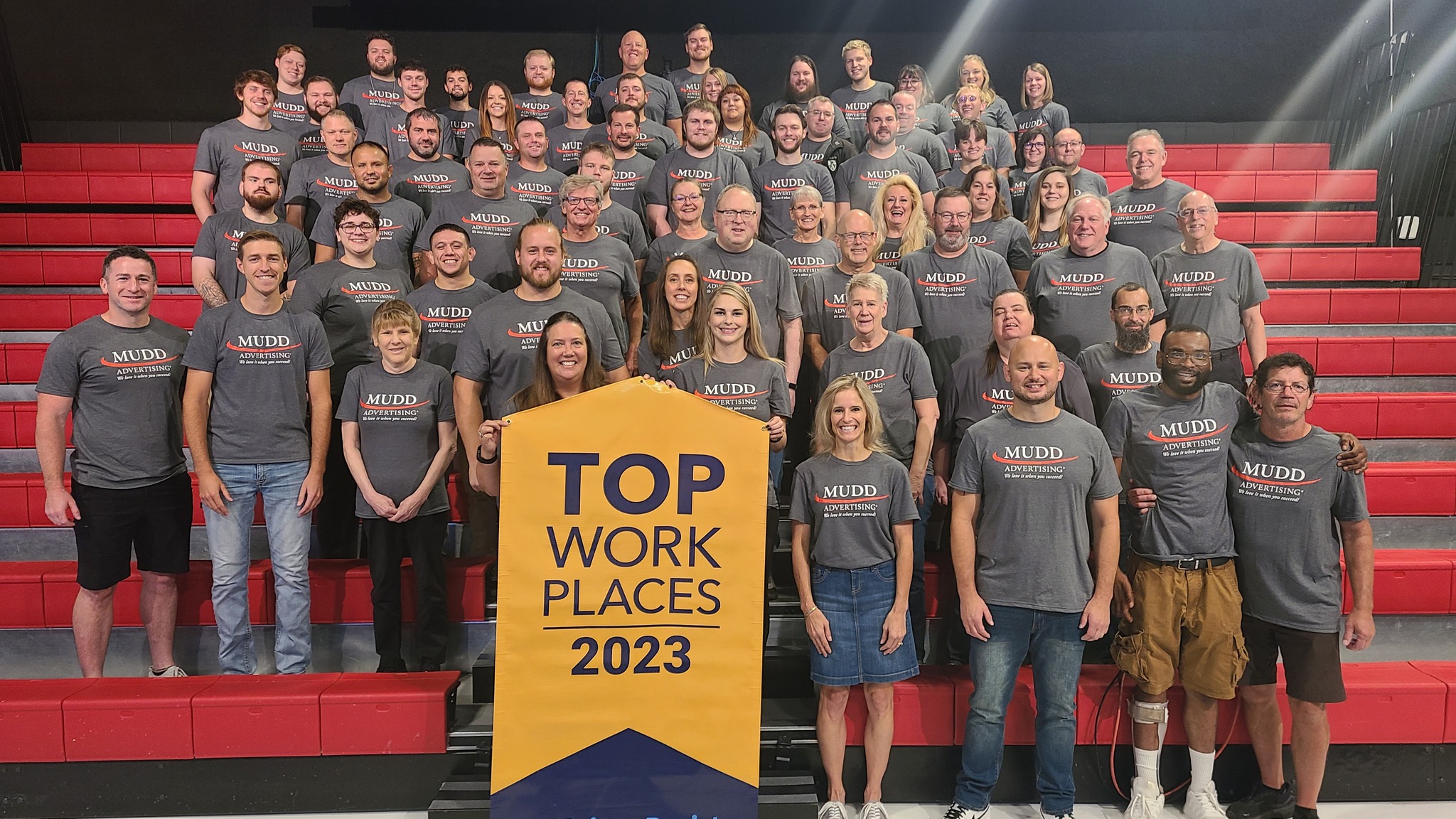 Mudd group photo of employees. In the front is a banner that reads "Top work places 2023"